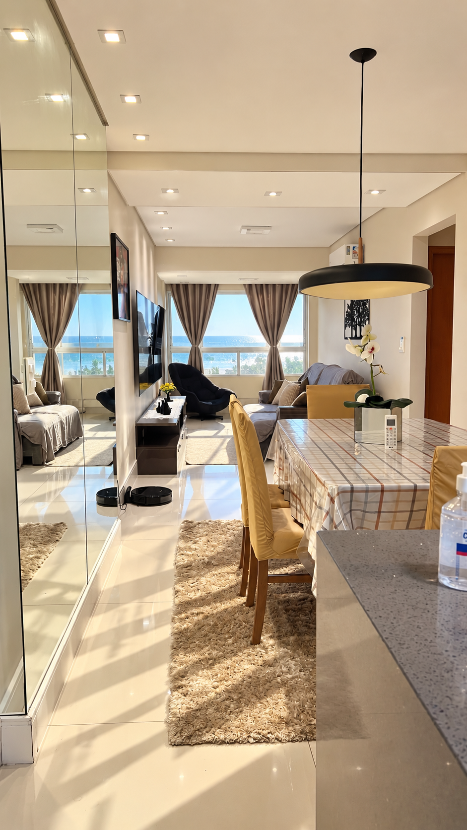 Sala de jantar do Maré integrada à sala com vista para o mar